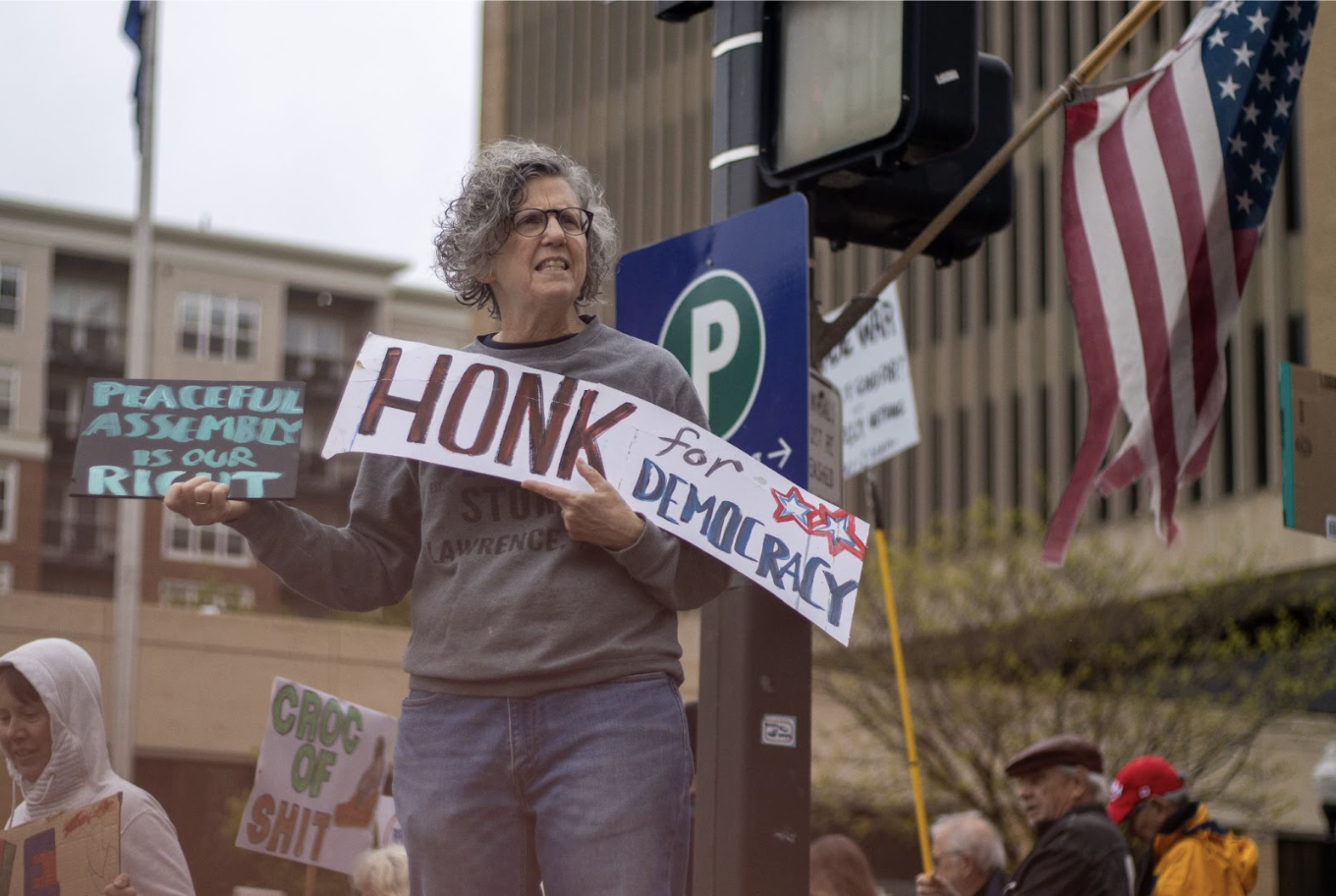 Joining in a chant during the weekly protest on Easter Sunday, Kelly Barth protests the importance of democracy. “We need to stop this rogue presidency, and the people need to rise up,” Barth said. 